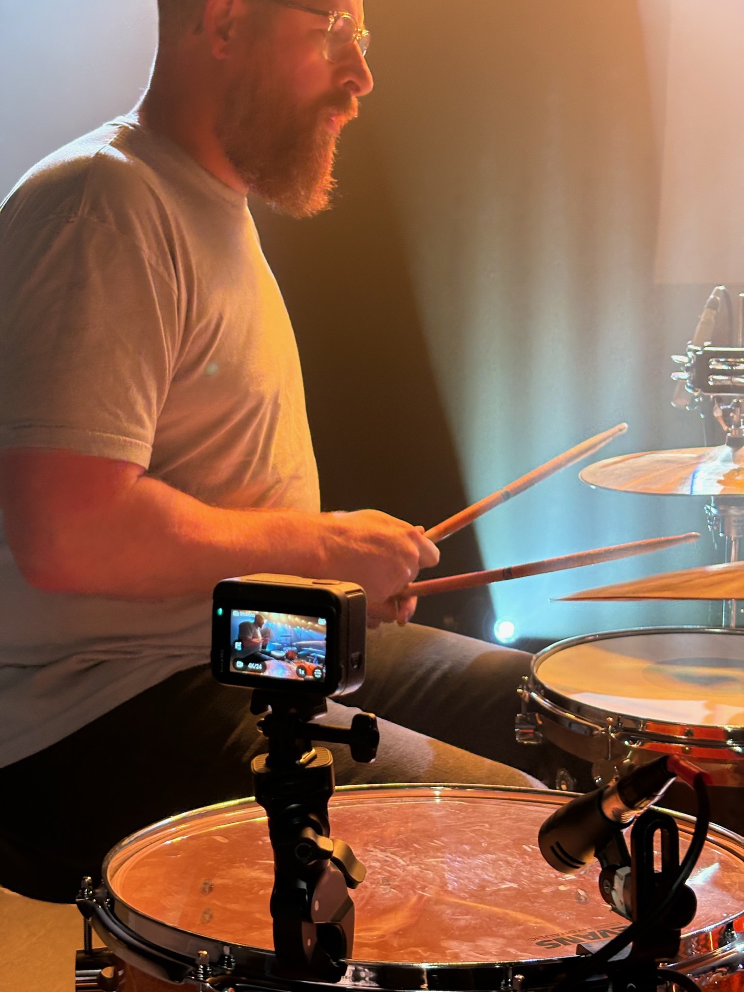 A GoPro clamped to the snare, its screen showing the live shot