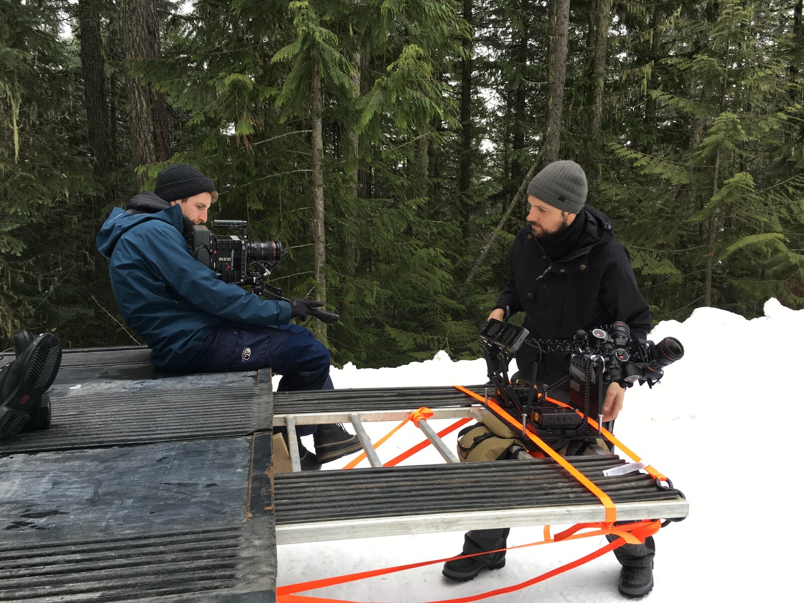 The rig strapped to a platform in a snowy forest, two crew members alongside