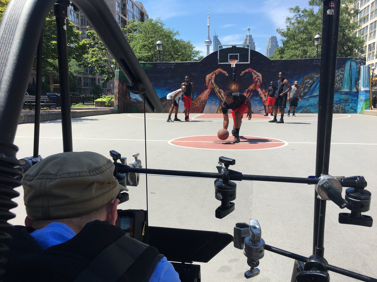 Looking out from behind the camera rig at the outdoor basketball court
